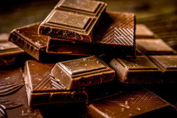 chopped chocolate pieces for dessert dark wooden desk background