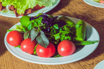 Vegetarian salad with cucumbers, tomatoes . Vegan salad on a white plate. breakfast top viewCucumbers and tomatoes on a white plate. Vegetarian salad . Cucumbers and tomatoes on a white plate.