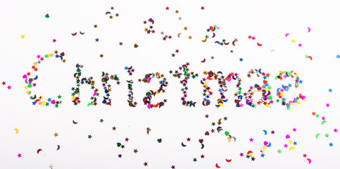 the word Christmas is written in sequins on a white background