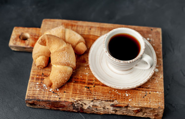 Coffee and croissants on a stone background. delicious morning breakfast