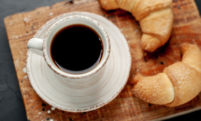 Coffee and croissants on a stone background. delicious morning breakfast
