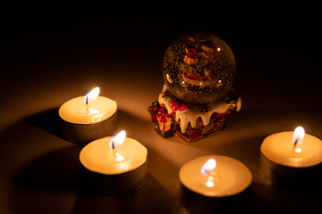 Weihnachtsmann freut sich im Kerzenschein der Adventszeit in seiner Schneekugel auf Heiligabend und die strahlenden funkelnden Kinderaugen am Weihnachtsfest