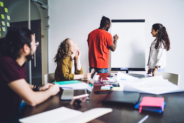 Young casual students with whiteboard in class