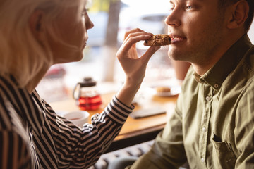 Beautiful woman feeding her boyfriend in the cafe