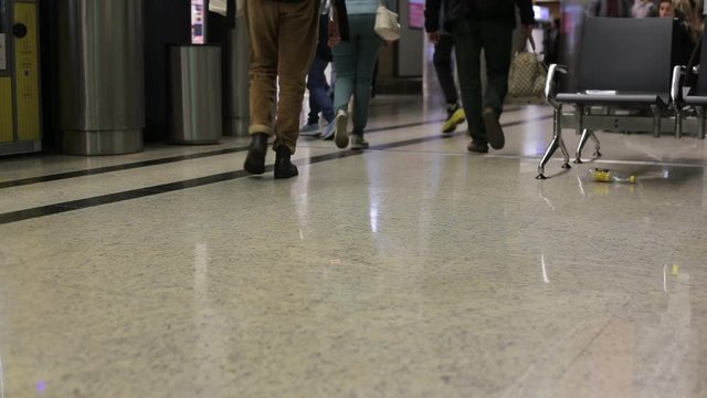 People with luggage walking in airport, low side shot