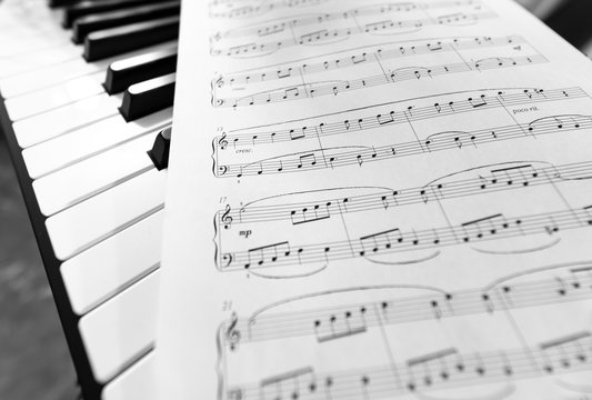 Classic piano and musical sheet . Black and white photo, Musical Background
