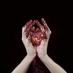 beautiful woman hands with glitter holding apple close up