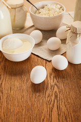 selective focus of various fresh organic dairy products and eggs on rustic wooden table