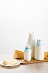 various fresh organic dairy products on wooden board isolated on white