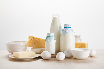 various fresh organic dairy products and eggs on wooden table isolated on white