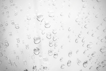 Raindrop water dew drop on glass wet white gray blue background.