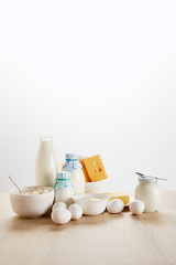 Fototapeta na wymiar delicious organic dairy products and eggs on wooden table isolated on white
