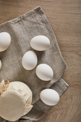 top view of eggs and milk on wooden table with napkin