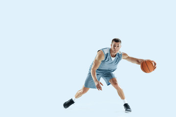 Plakat Passioned for. Young caucasian basketball player of team in action, motion in jump isolated on blue background. Concept of sport, movement, energy and dynamic, healthy lifestyle. Training, practicing.