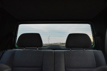 backward view from inside a small car on a cloudy day