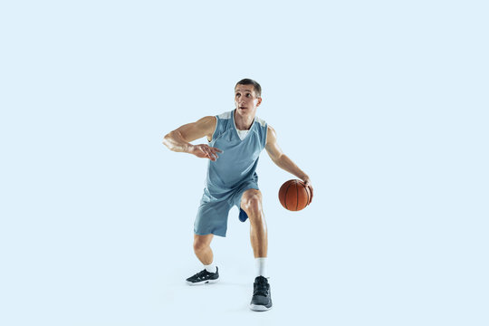 Energy. Young caucasian basketball player of team in action, motion in jump isolated on blue background. Concept of sport, movement, energy and dynamic, healthy lifestyle. Training, practicing.
