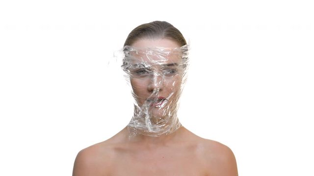 Woman's face covered with transparent plastic and depressed expression on isolated white background ideal for women abuse awareness campaign