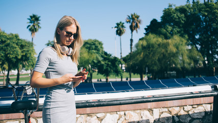 Casual woman with mobile phone on street