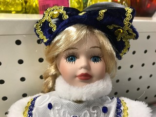 Frightened snow maiden doll close-up in the store.Portrait of a blonde doll with blue eyes, blue...