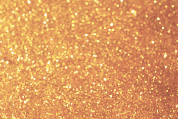 Golden sparkle glitters with bokeh effect and selectieve focus. Festive background with bright gold lights, champagne bubble. Christmas mood concept. Copy space, close up, texture, top view.