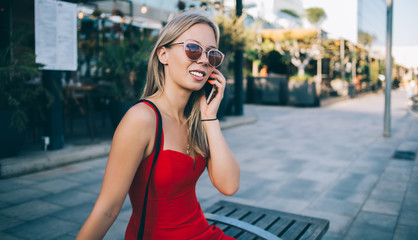 Stylish woman speaking on phone on street