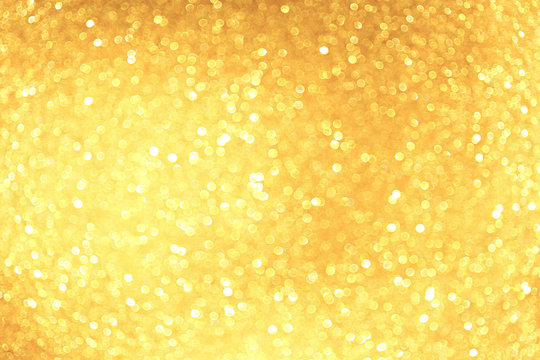 Golden sparkle glitters with bokeh effect and selectieve focus. Festive background with bright gold lights, champagne bubble. Christmas mood concept. Copy space, close up, texture, top view.
