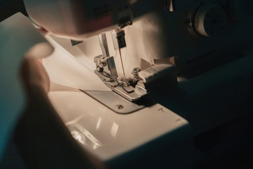 A sewing machine is sewing fabric.
