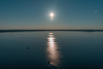 Sun in the sky over an open lake