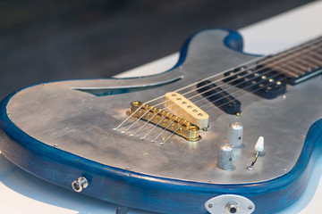 E-Gitarre mit goldenem Steg, silbernen Saiten, Holzstegen und silbernem Korpus als Rock Band...