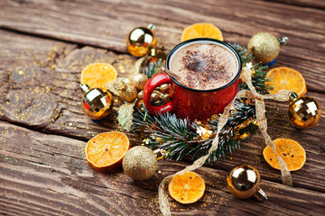 Christmas composition. Red Cup with cappuccino coffee over wooden background. Close-up with space for text.