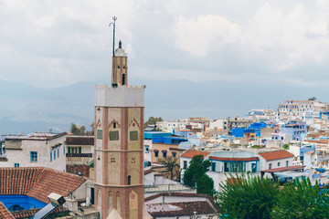 Fototapeta na wymiar landscape. rooftops, a tower, and in the distance mountains in the fog. Morocco