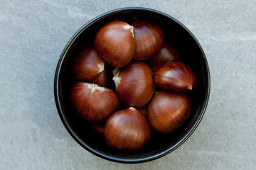 Edible chestnuts in a black bowl.