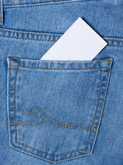 a business card is visible from a blue denim pocket. Place for copy, business concept
