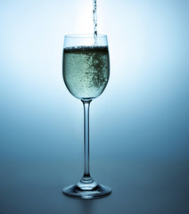 Glass with champagne. Champagne is pouring into a glass.