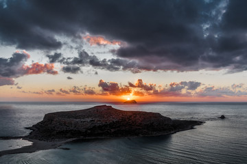 Naklejka na ściany i meble Sunset on the background of a small island