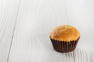 Tasty cupcake  on a wooden table.