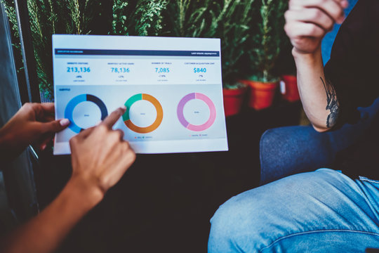 Cropped view of paper report with diagram statistics of informational data, male and female financial professionals discussing ideas for productive working of business startup project analyzing plan