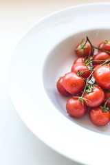 Ripe fresh red cherry tomatoes on a white background