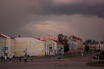 Sights and views of Grodno. The city street after the rain, evening, the sky with storm clouds, the youth for an evening walk, passers-by.