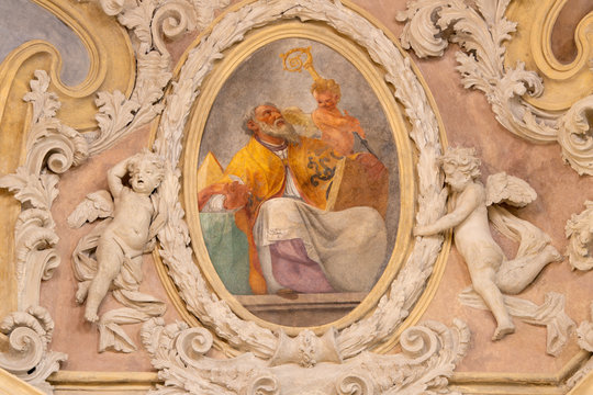 RIVA DEL GARDA, ITALY - JUNE 13, 2019: The baroque fresco of St. Ambrose doctor of the west catholic church in church Chiesa di Santa Maria Assunta  by Teofilo Polacco from beginn of 19. cent..
