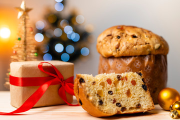 Delicious Panettone slice with candied fruits with blinking blurred christmas lights. Dry fruits....