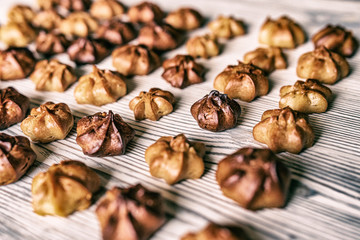 Choux pastry on a wooden background. Photographed in high key, closeup.