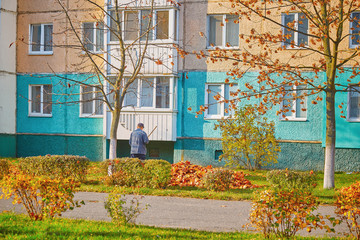 Fototapeta na wymiar The Man sweeping leaves fall to the ground lawn at home in morning with sunlight background