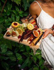 Young girl holding tklapi dried mashed fruit candy pastille pulp. Colorful leather from apricot, kiwi, dogwood, strawberry. Cuisine roll up snack. Grapes, dates, lemon, orange, raspberries. Board.