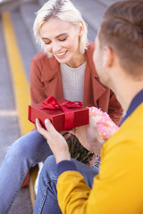 Woman being a little shy while receiving birthday gift