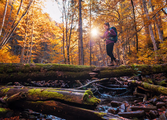 girl with a backpack crosses the stream