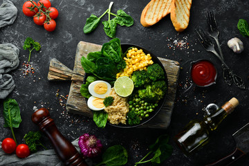 Green vegetable bowl Buddha. quinoa, green peas, corn, spinach, broccoli, egg. Healthy food. Top view. Free space for your text.