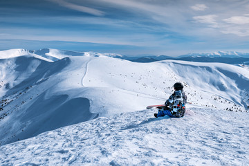snowboarder sits on a mountainside