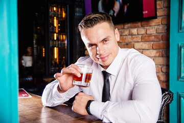 Businessman drinks whiskey at the bar