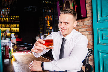 Businessman drinks whiskey at the bar